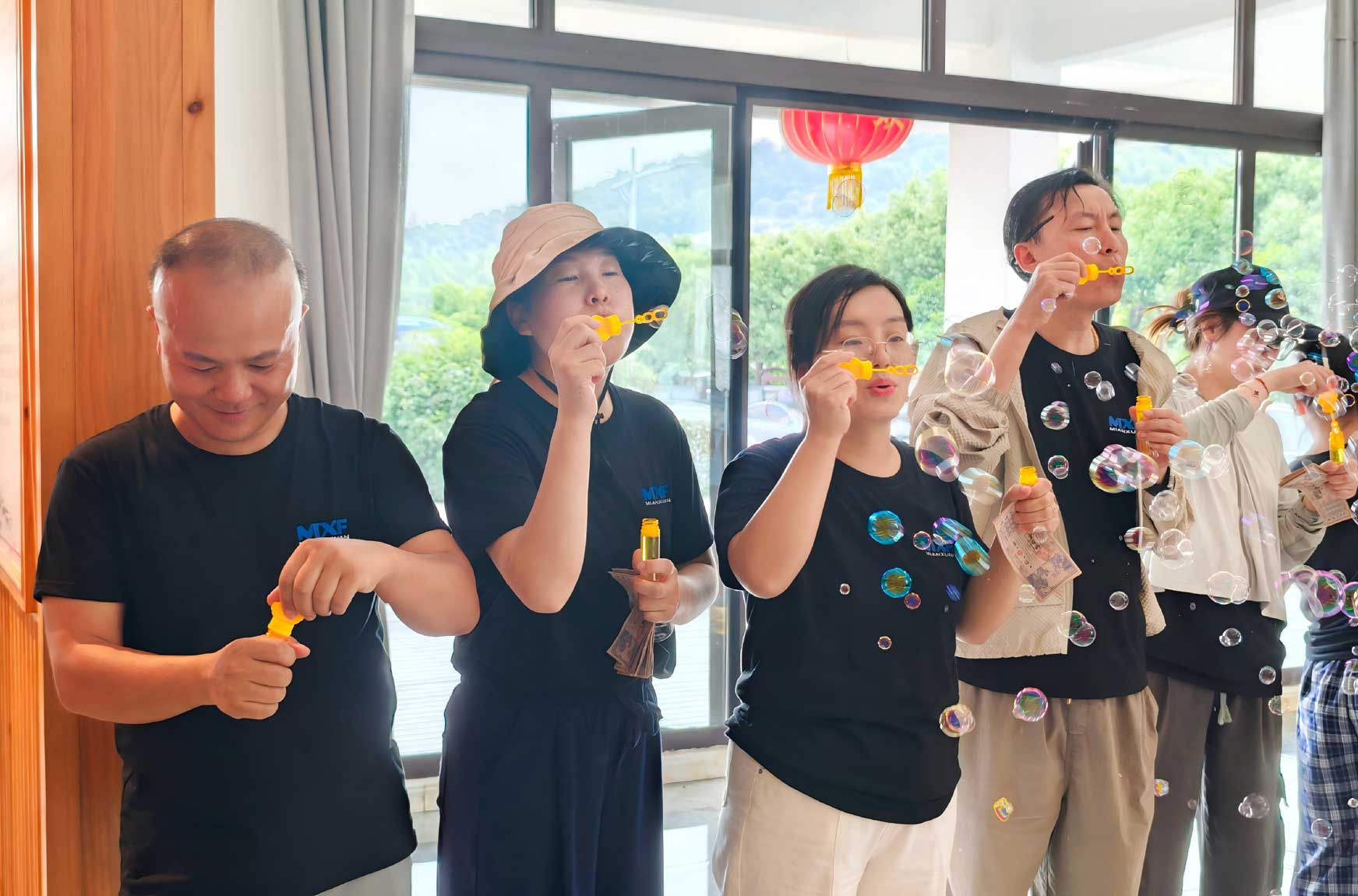 Mianxuan Fastener team members blowing bubbles together at the end of Nanlian Village team building